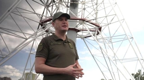 Yurii Shchyhol stands outside in front of a tower