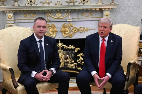 Трамп і Навроцький на золотистих кріслах Овального офісу на тлі мармурового каміна з позолотою. Обидва сидять на краю крісел, опираються руками на ноги, долоні мають зібрані