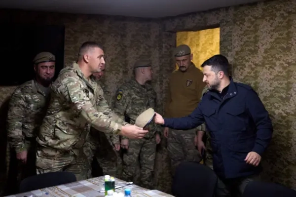 Командир 425-го полку Гаркавий вручає Зеленському берет в кімнаті в оточенні солдатів