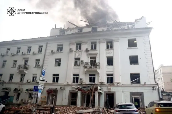 Пошкоджена будівля з чорним димом над нею