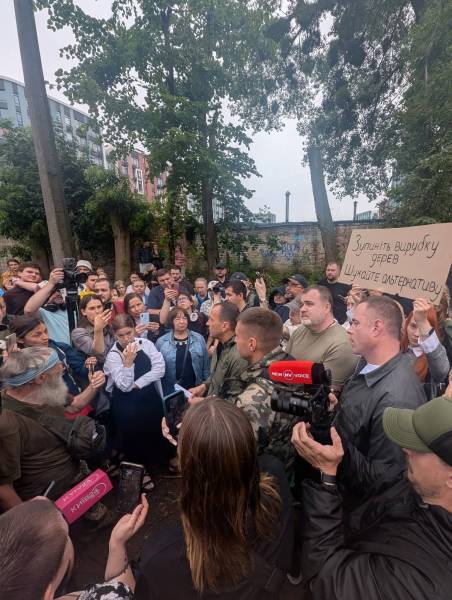 З активістами розмовляє заступник голови КМДА Петро Пантелеєв. На фото він в однотонній зеленій куртці
