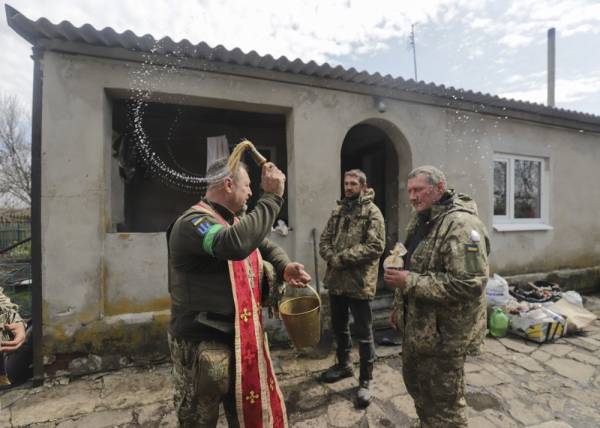 Військовий капелан кропить військових свяченою водою під час святкування Великодня неподалік від їхніх позицій, Харківська область, 24 квітня 2022 року.